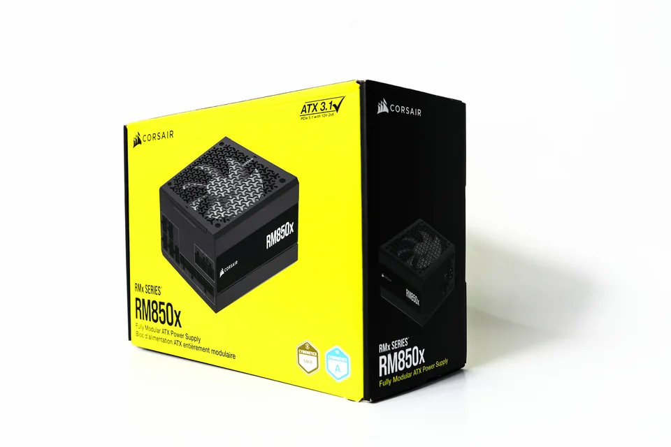 CORSAIR 电脑电源包装彩盒实拍：黄黑配色的盒装包装，正面产品图与侧面图文形成连续展示。