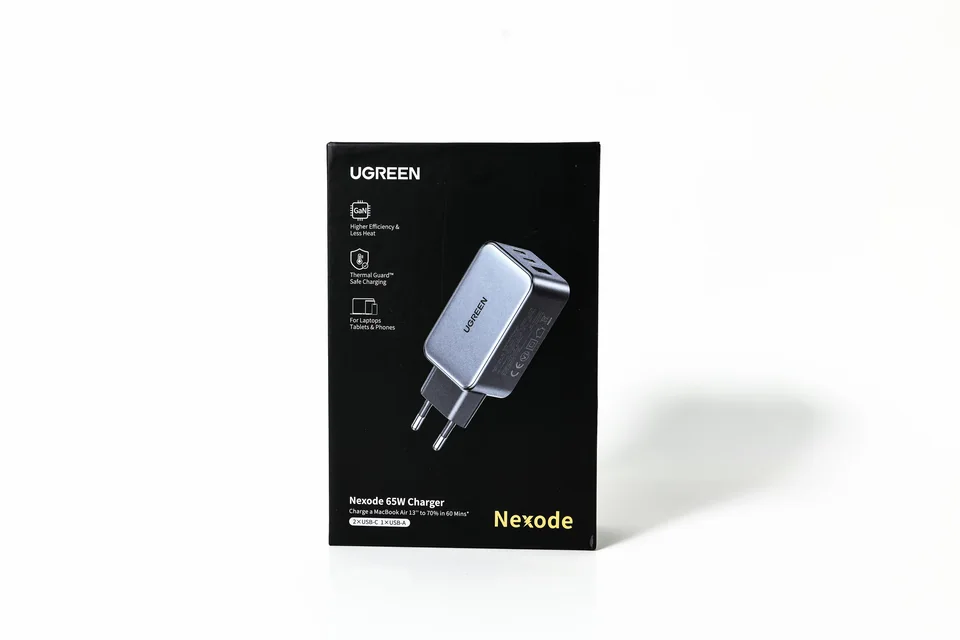 绿联 Nexode 充电器包装彩盒实拍：深色竖式彩盒，以充电器图像和简洁的正面信息呈现产品。