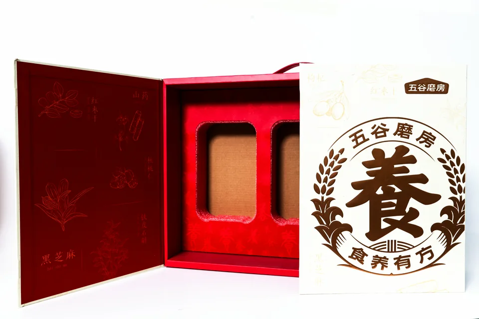 五谷磨房食品营养礼盒实拍：展开的礼盒展示红色内部结构及分隔位置，外盒以品牌图文呈现。